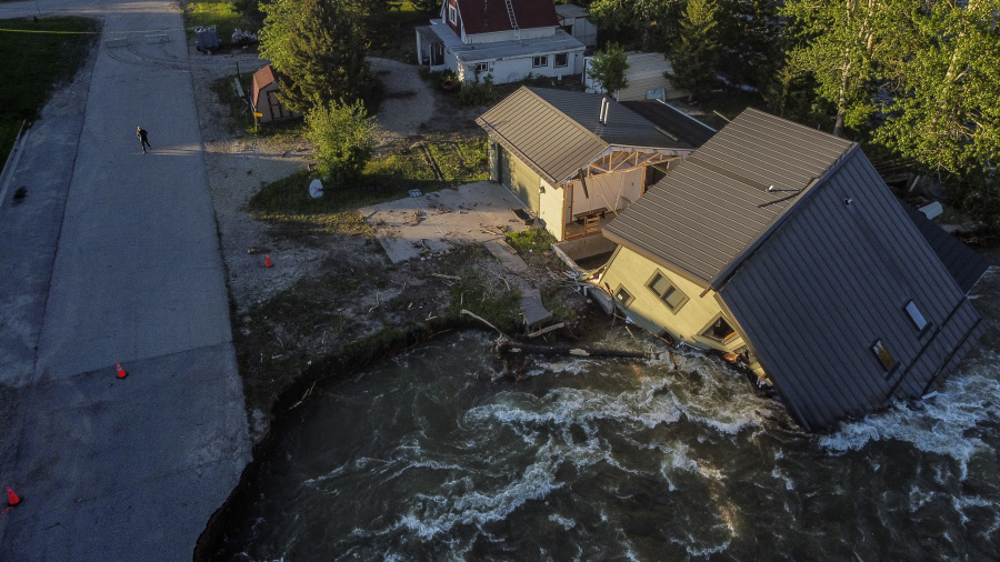 FILE - A house sits in Rock Creek after floodwaters washed away a road and a bridge in Red Lodge, Mont., Wednesday, June 15, 2022. After three nasty years, the La Nina weather phenomenon is gone, the National Oceanic and Atmospheric Administration said Thursday, March 9, 2023.