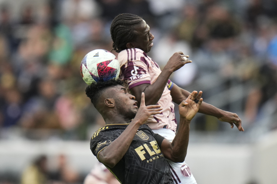 Los Angeles FC midfielder Jose Cifuentes, bottom, heads the ball against Portland Timbers midfielder Diego Chara during the first half of an MLS soccer match, Saturday, March 4, 2023, in Los Angeles. (AP Photo/Jae C.