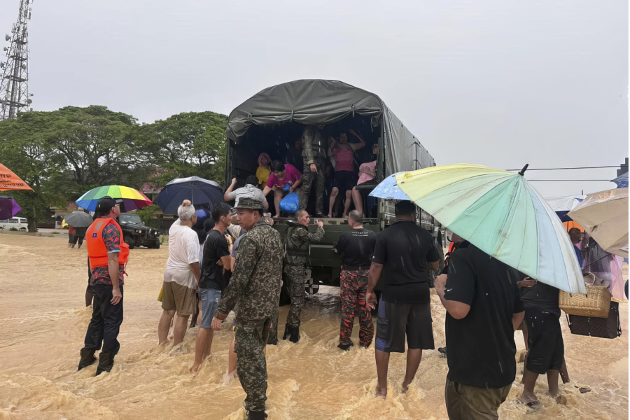 In this photo released by National Disaster Management Agency, the army evacuate residents on Chaah town in Segamat, in southern Johor state, Malaysia, Wednesday, March 1, 2023. Rescuers in boats plucked flood victims trapped on rooftops and hauled others to safety as incessant rain submerged homes and villages in parts of Malaysia, leading to over 26,000 people evacuated as of Thursday.