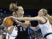 Portland guard Maisie Burnham, left, protects the ball from Oklahoma guard Aubrey Joens during the second half of a first-round college basketball game in the women's NCAA Tournament, Saturday, March 18, 2023, in Los Angeles.