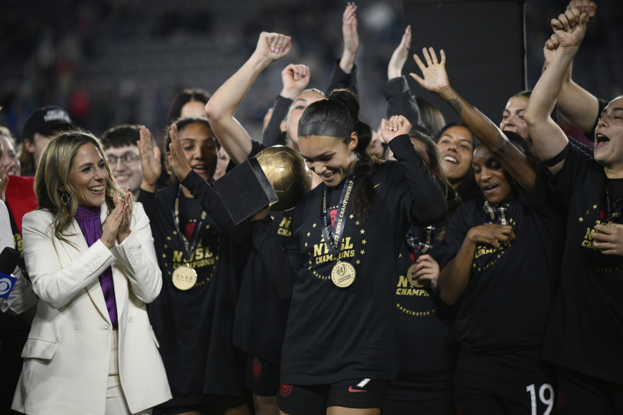 FILE - Portland Thorns forward Sophia Smith holds the MVP trophy after the team's NWSL championship soccer match against the Kansas City Current, Oct. 29, 2022, in Washington. At left is NWSL Commissioner Jessica Berman. Portland is also among the favorites this season because of a loaded roster that includes U.S. national team players like Sophia Smith, Crystal Dunn and Becky Sauerbrunn.