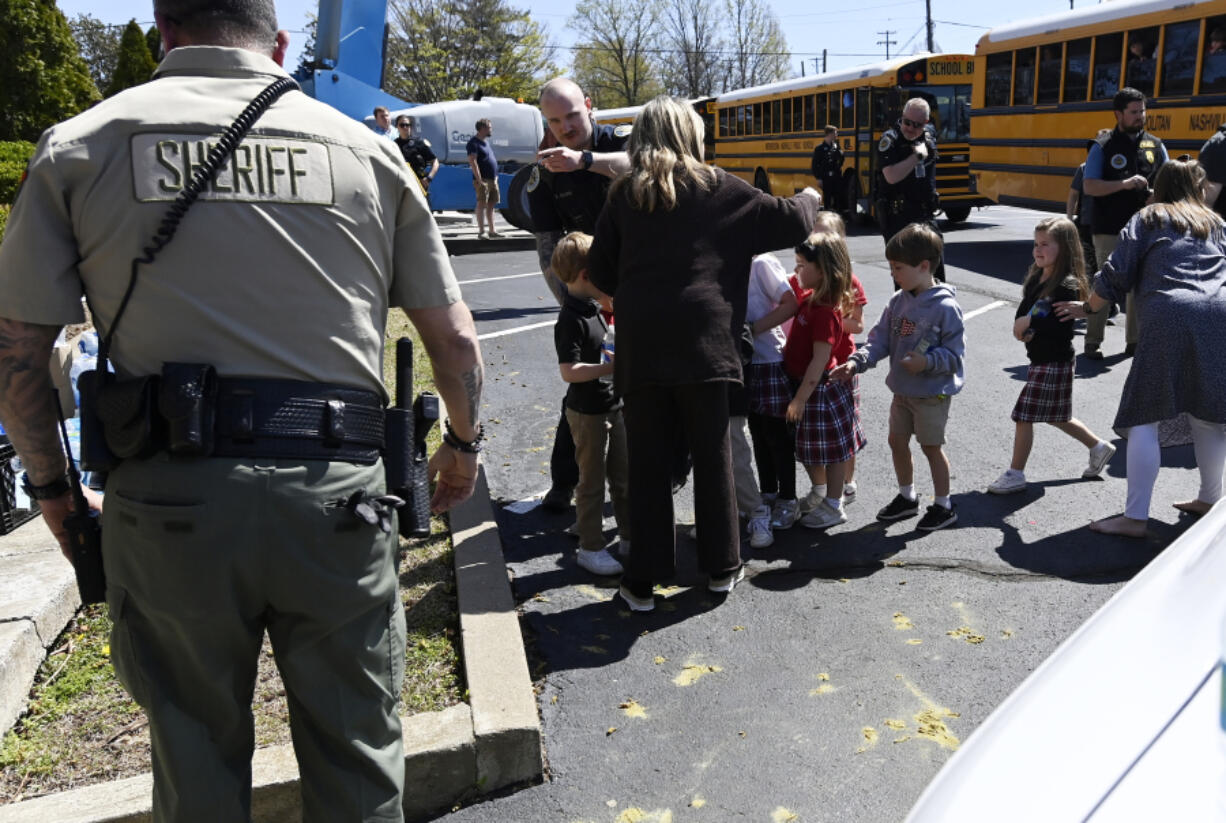 Students from The Covenant School get off a bus to meet their parents at the reunification site at the Woodmont Baptist Church Monday, March 27, 2023, in Nashville, Tenn. following a mass shooting at their school, where three children and three adults were killed by a perpetrator that was killed by police at the scene.