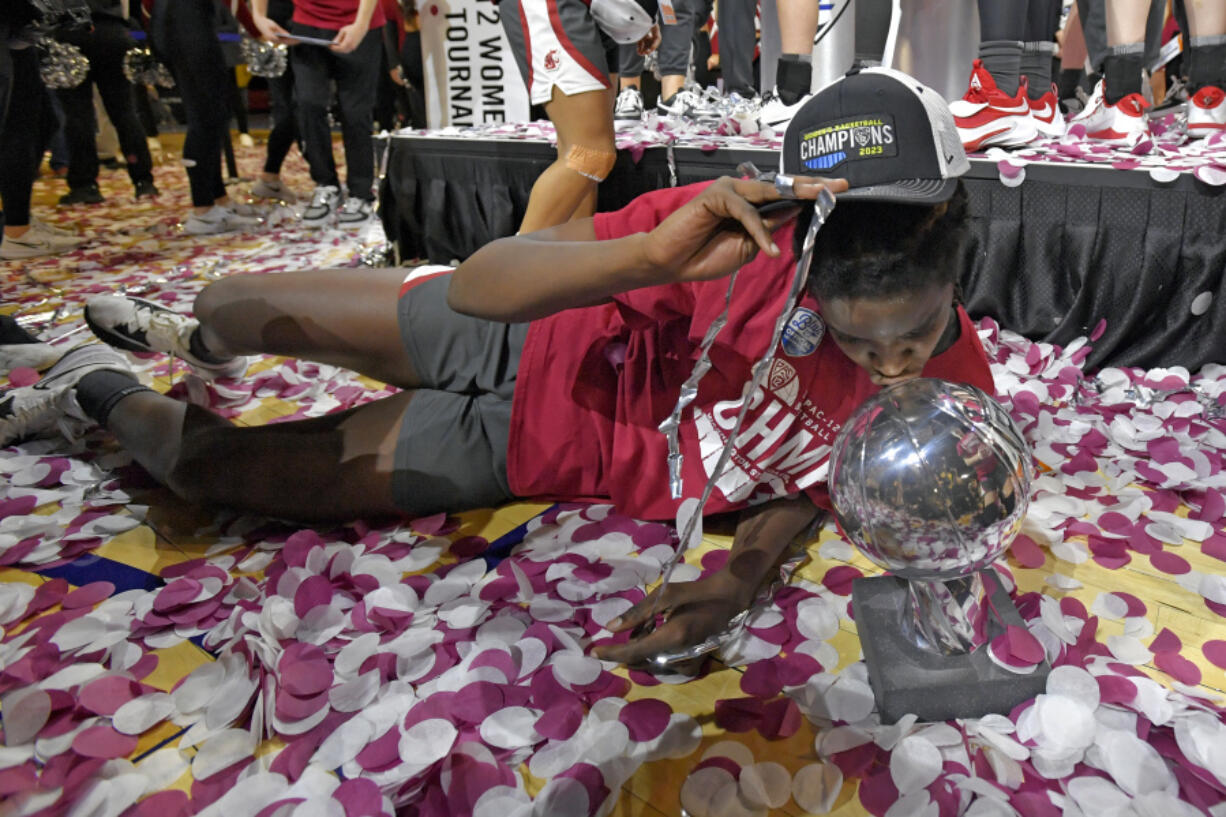 Washington State center Bella Murekatete kisses the championship trophy after defeating UCLA in an NCAA college basketball game in the finals of the Pac-12 women's tournament Sunday, March 5, 2023, in Las Vegas.