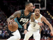 Portland Trail Blazers guard Damian Lillard, left, drives to the basket against New Orleans Pelicans guard CJ McCollum during the first half of an NBA basketball game in Portland, Ore., Wednesday, March 1, 2023.