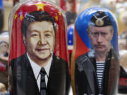 Russian matryoshka dolls with portraits of the Chinese President Xi Jinping, left, and Russian President Vladimir Putin are displayed among others for sale at a souvenir shop in Moscow, Russia, Tuesday, March 21, 2023. Chinese President Xi Jinping arrived in neighbouring Russia for a three-day trip for the talks with Russian President Vladimir Putin.