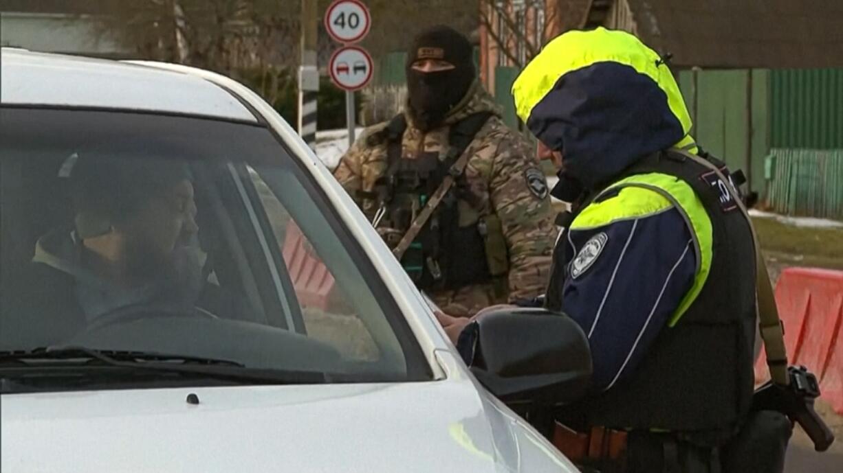 In this image taken from footage provided by the RU-RTR Russian television on Friday, March 3, 2023, a Russian policeman checks documents of drivers not far from the border between Russia and Ukraine in Russia. Russia has declared that a group of saboteurs from Ukraine crossed into its territory and attacked border villages, a raid marking an escalation of the war that dragged into a second year. On Friday, the Russian leader had a video call with members of his Security Council, saying in opening remarks that it will focus on tightening protection against terrorist attacks but giving no details.