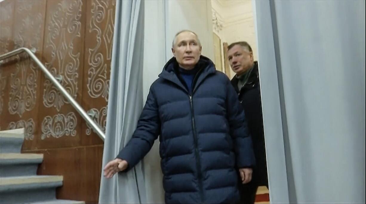 In this photo taken from video released by Russian TV Pool on Sunday, March 19, 2023, Russian President Vladimir Putin escorting by Russian Deputy Prime Minister Marat Khusnullin visits the Mariupol theater during his visit to Mariupol in Russian-controlled Donetsk region, Ukraine.