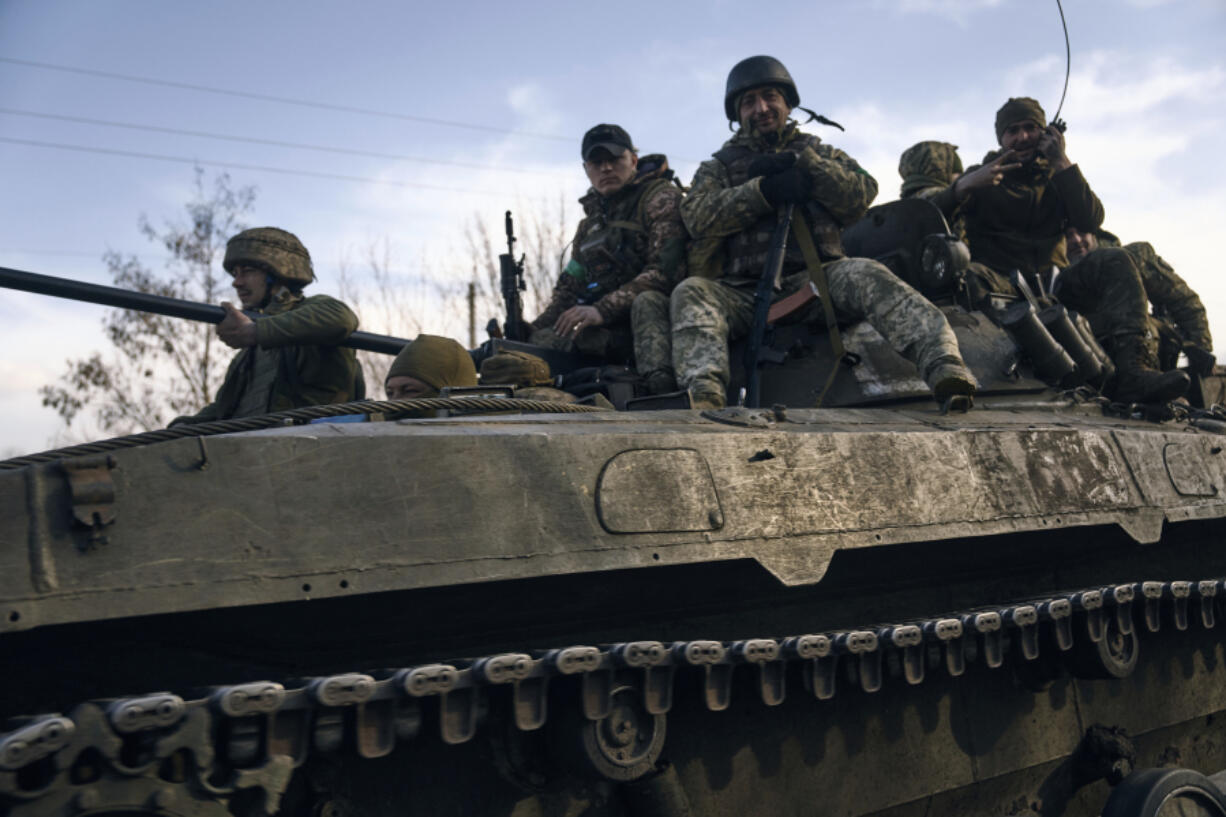 Ukrainian soldiers ride atop an APC on the frontline in Bakhmut, Donetsk region, Ukraine, Wednesday, March 22, 2023.