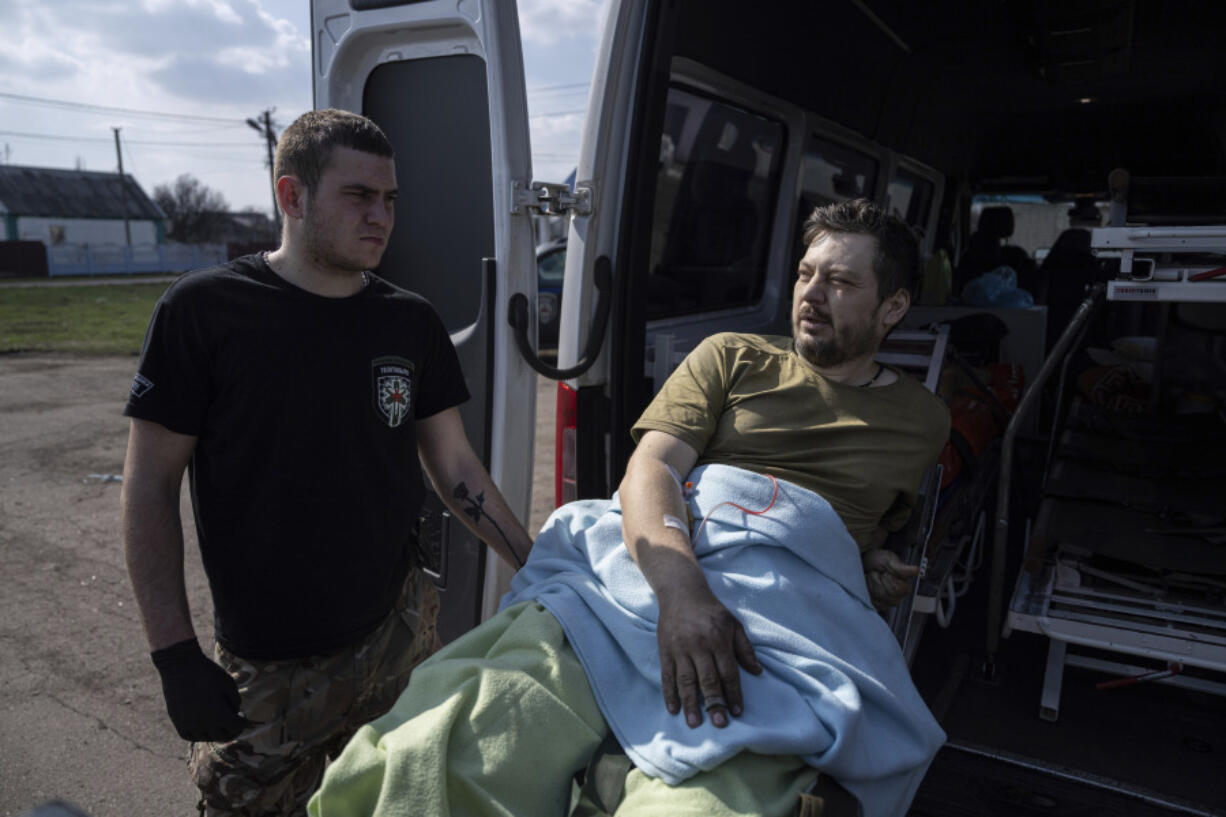 Yaroslav, 37, an injured Ukrainian soldier, lies on a stretcher before evacuation by volunteers from the Hospitallers paramedic organisation near a special medical bus in Donetsk region, Ukraine, Wednesday, March 22, 2023.