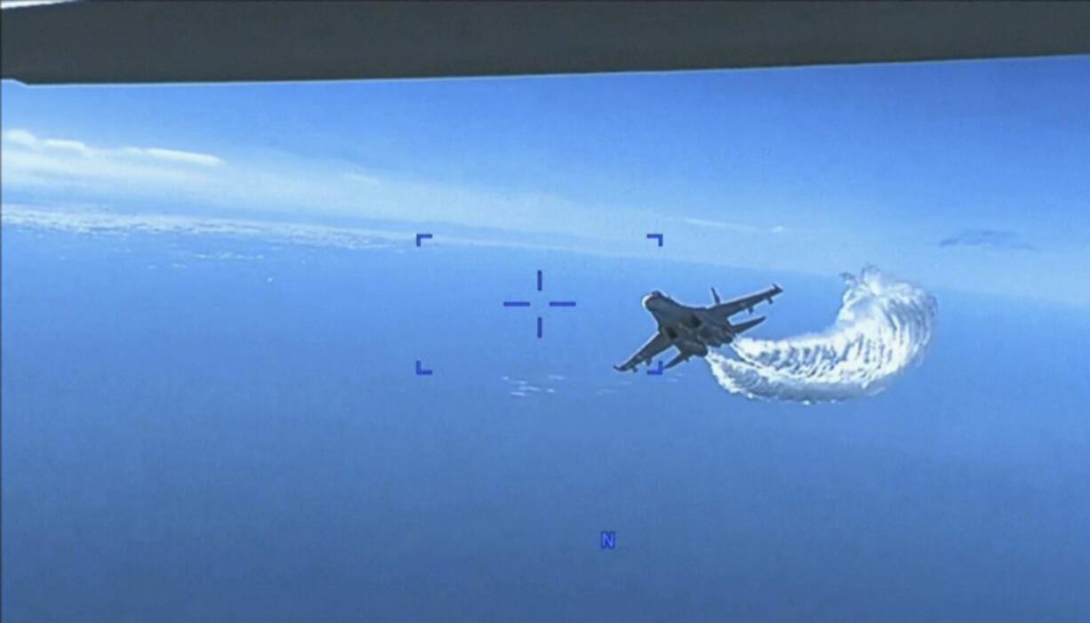 This photo taken from video released on Thursday, March 16, 2023, shows a Russian Su-27 approaching the back of the MQ-9 drone and beginning to release fuel as it passes, over the Black Sea, the Pentagon said. The Pentagon has released footage of what it says is a Russian aircraft conducting an unsafe intercept of a U.S. Air Force surveillance drone in international airspace over the Black Sea.