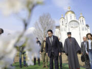 Japanese Prime Minister Fumio Kishida, center, offers prayers at a church in Bucha, a town outside Kyiv that became a symbol of Russian atrocities against civilians, in Ukraine, Tuesday, March 21, 2023.(Iori Sagisawa/Kyodo News via AP)