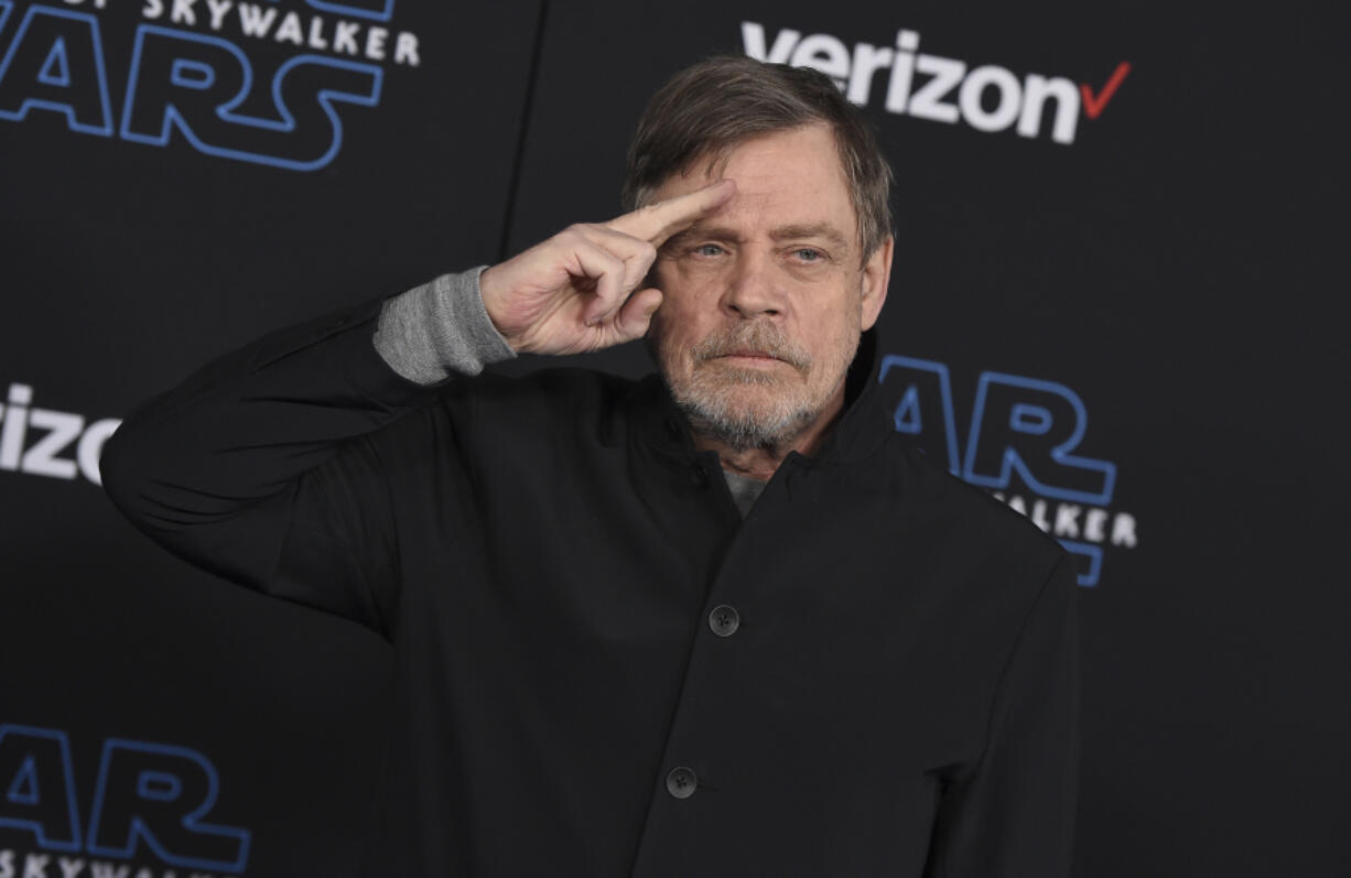 FILE - Mark Hamill salutes as he arrives at the world premiere of "Star Wars: The Rise of Skywalker" in Los Angeles on Dec. 16, 2019. When air raid alarms sound in Ukraine, they also trigger a downloadable app that has been voiced by "Star Wars" actor Mark Hamill. With his gravely but also calming baritone, he urges people to take cover.