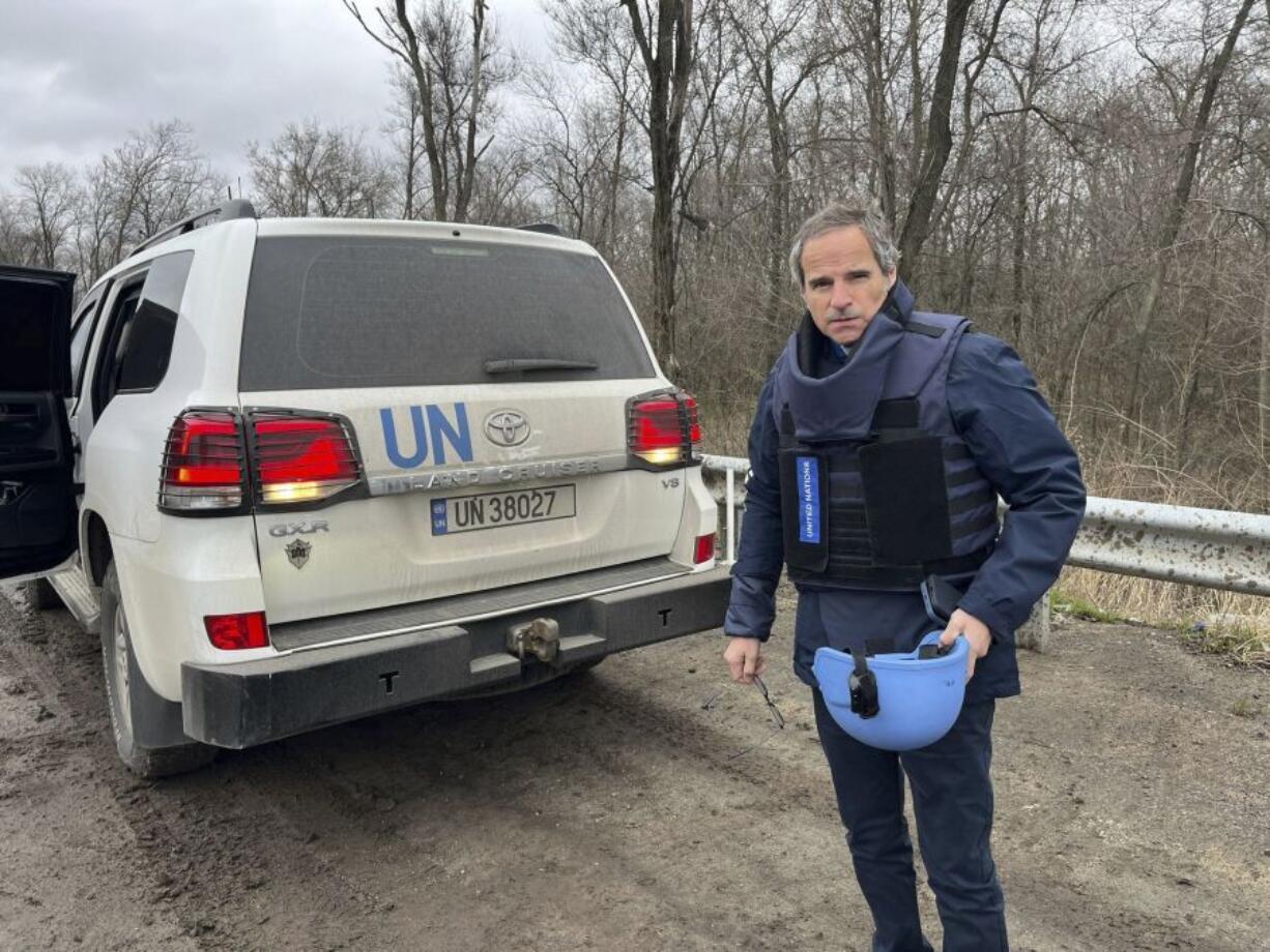 In this photo provided by the IAEA Press Office, U.N. atomic energy chief Rafael Mariano Grossi stands on a road next to a UN vehicle on his way to the Zaporizhzhia Nuclear Power Plant, in southeastern Ukraine, Wednesday March 29, 2023.