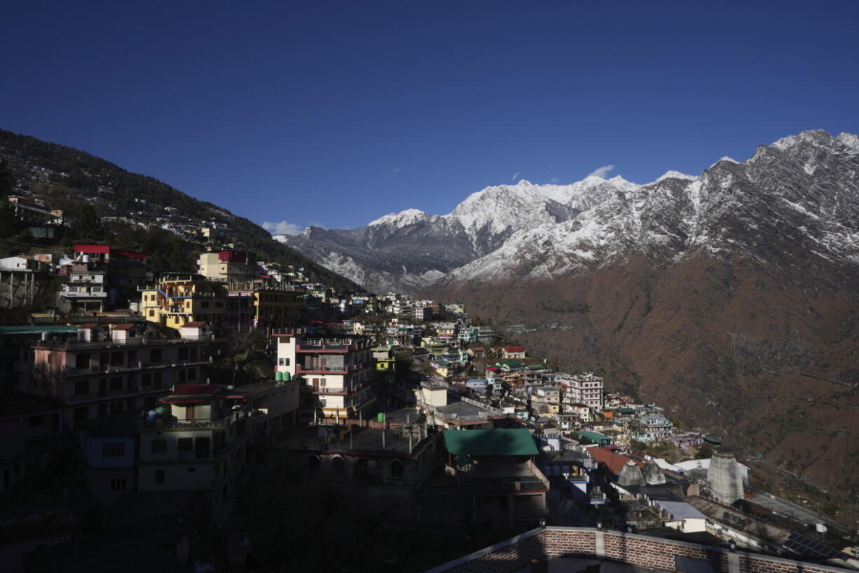 Joshimath town is seen along side snow capped mountains, in India's Himalayan mountain state of Uttarakhand, Jan. 21, 2023. For months, residents in Joshimath, a holy town burrowed high up in India's Himalayan mountains, have seen their homes slowly sink. They pleaded for help, but it never arrived. In January however, their town made national headlines. Big, deep cracks had emerged in over 860 homes, making them unlivable.