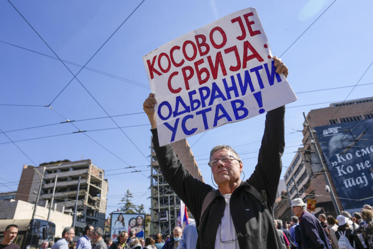 A man holds a banner reading: ''Kosovo is Serbia: defend the constitution!'' during a "warning protest" against the 11-point plan that U.S and European Union officials presented as a way out of a decades-long problem between Serbia and Kosovo, in Belgrade, Serbia, Friday, March 24, 2023. Supporters of Serbian right-wing opposition parties on Friday demanded that populist President Aleksandar Vucic and his government resign over a Western-backed plan for normalization of relations with Kosovo.
