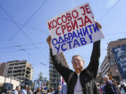 A man holds a banner reading: ''Kosovo is Serbia: defend the constitution!'' during a "warning protest" against the 11-point plan that U.S and European Union officials presented as a way out of a decades-long problem between Serbia and Kosovo, in Belgrade, Serbia, Friday, March 24, 2023. Supporters of Serbian right-wing opposition parties on Friday demanded that populist President Aleksandar Vucic and his government resign over a Western-backed plan for normalization of relations with Kosovo.