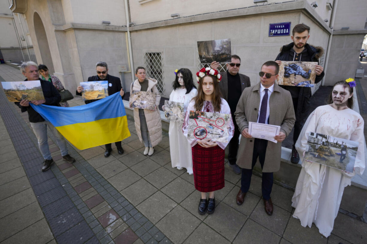 People attend a rally to mark the anniversary of the liberation of Bucha, a town outside Kyiv that became a symbol of Russian atrocities against civilians, near the Russian embassy, in Belgrade, Serbia, Friday, March 31, 2023.