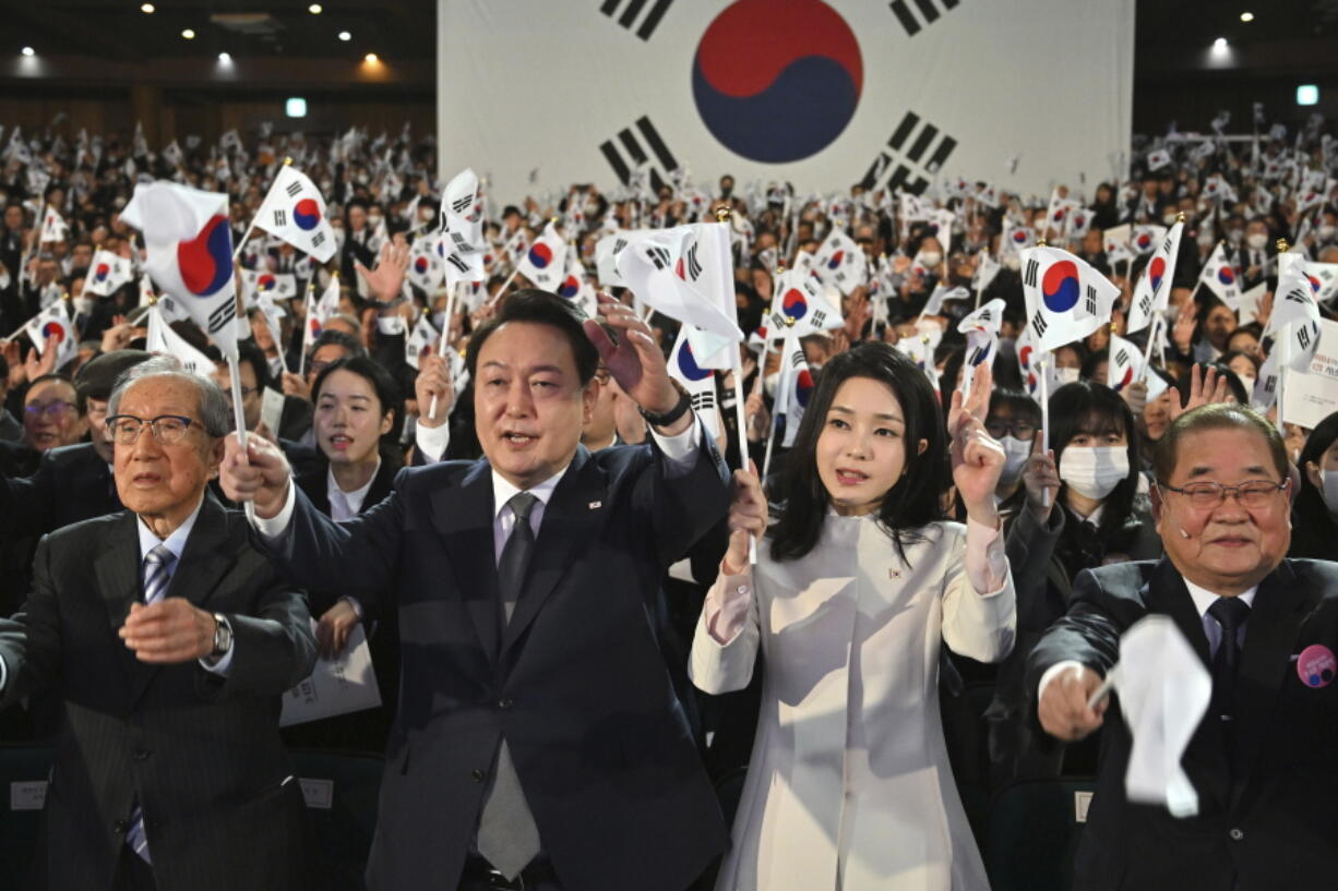 South Korea's President Yoon Suk Yeol, center left, and his wife Kim Keon Hee, center right, give three cheers during a ceremony of the 104th anniversary of the March 1st Independence Movement Day against Japanese colonial rule, in Seoul Wednesday, March 1, 2023.