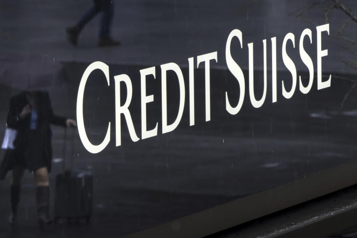 A woman walks past a logo of the Swiss bank Credit Suisse in Zurich, Switzerland, Friday, March 24, 2023.