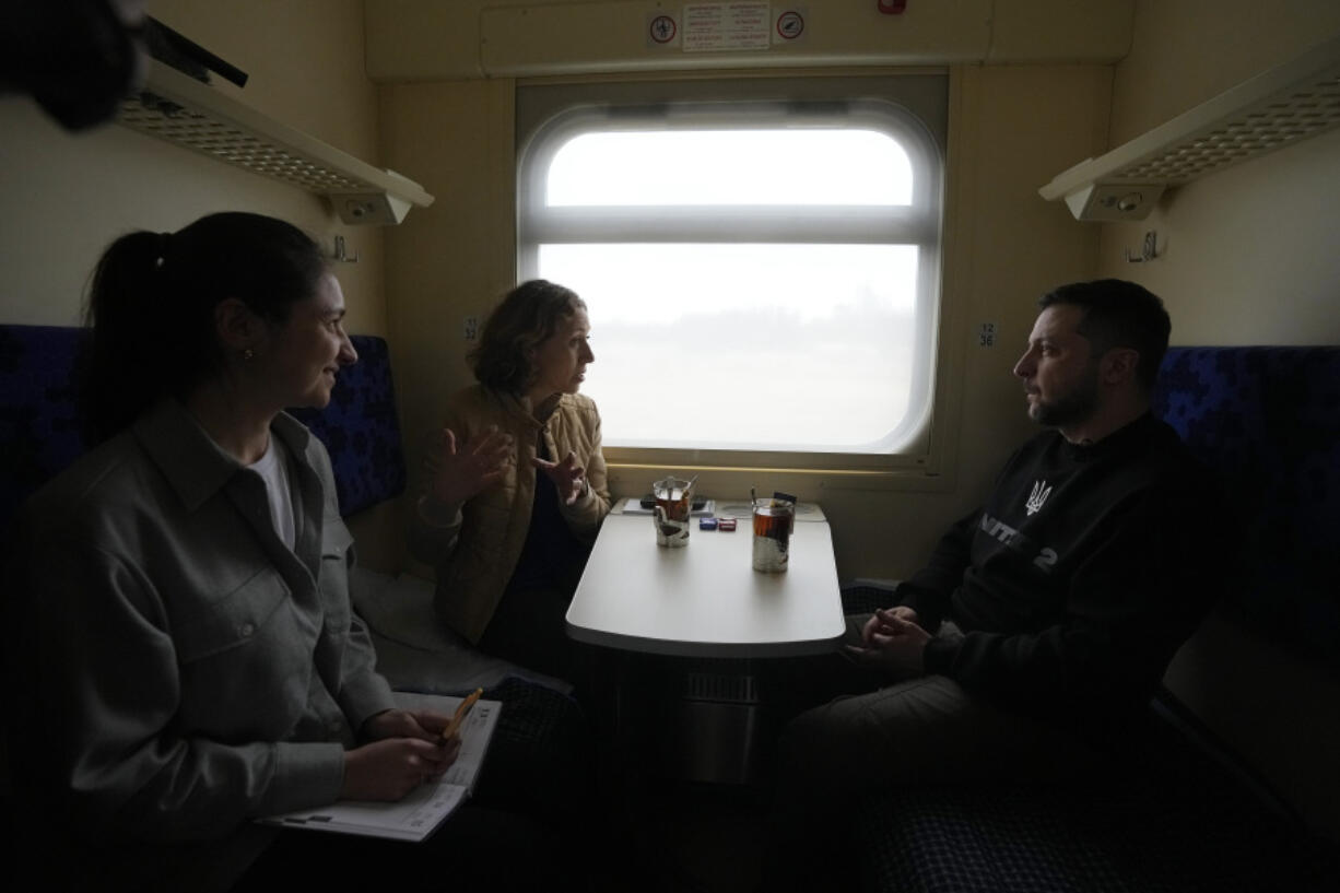 Ukrainian President Volodymyr Zelenskyy listens during an interview with Julie Pace, senior vice president and executive editor of The Associated Press, as Ukraine-based AP correspondent Hanna Arhirova, observes, on a train traveling from the Sumy region to Kyiv, Ukraine, Tuesday March 28, 2023. In the interview, Zelenskyy warned that unless his nation wins a drawn-out battle in the key eastern city of Bakhmut, Russia could begin building international support for a deal that could require Ukraine to make unacceptable compromises.