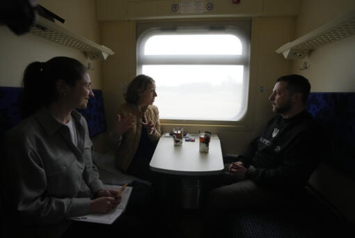 Ukrainian President Volodymyr Zelenskyy listens during an interview with Julie Pace, senior vice president and executive editor of The Associated Press, as Ukraine-based AP correspondent Hanna Arhirova, observes, on a train traveling from the Sumy region to Kyiv, Ukraine, Tuesday March 28, 2023. In the interview, Zelenskyy warned that unless his nation wins a drawn-out battle in the key eastern city of Bakhmut, Russia could begin building international support for a deal that could require Ukraine to make unacceptable compromises.