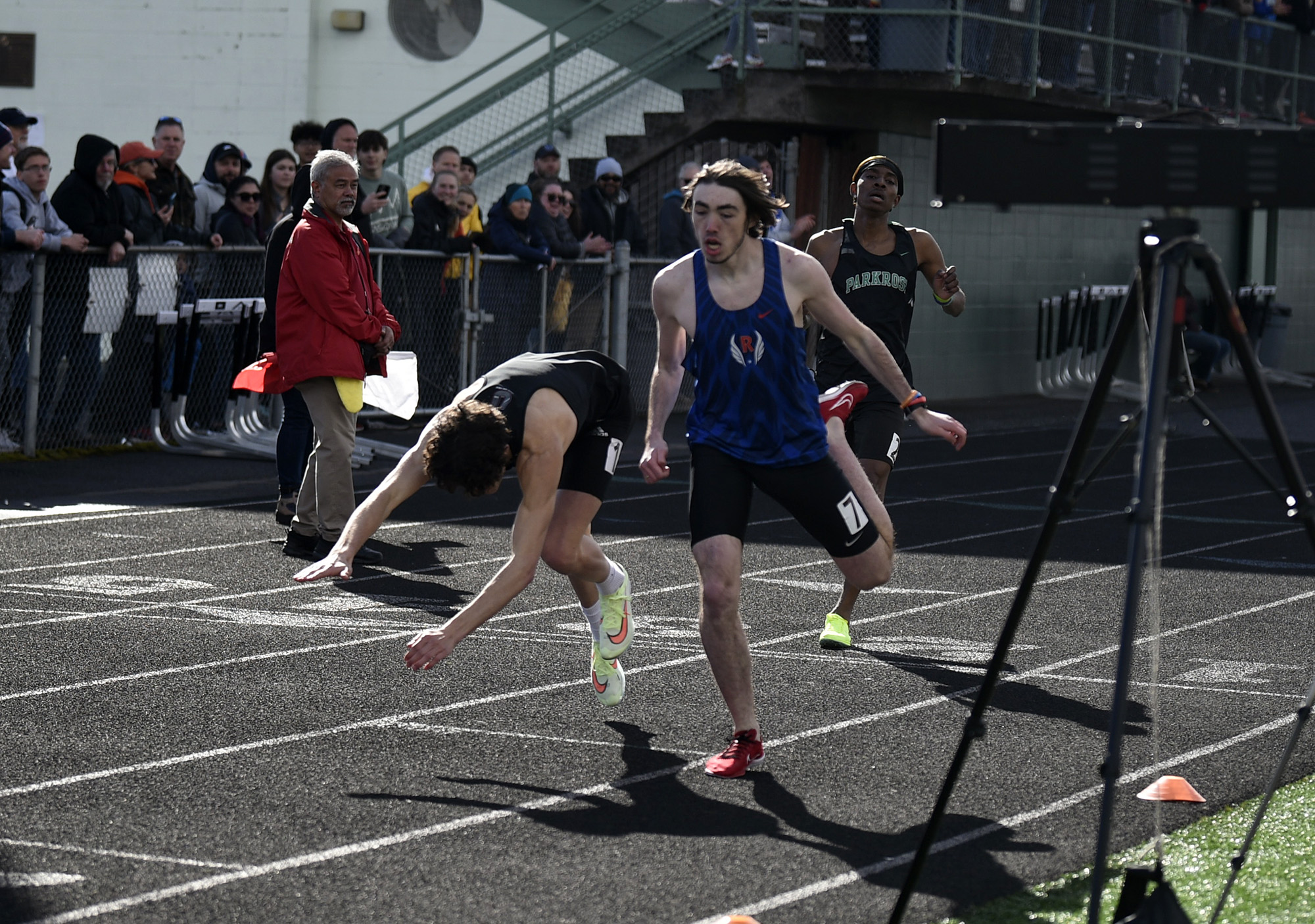 Union's Grayson Caldwell falls to the track after being edged out at the finish line by Liam Rapp of Ridgefield in the boys 800 meters at the Tiger Relays at Battle Ground High School on Saturday, March 25, 2023.