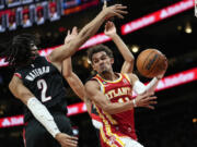 Atlanta Hawks guard Trae Young (11) passes the ball around Portland Trail Blazers' Trendon Watford (2) during the first half of an NBA basketball game Friday, March 3, 2023, in Atlanta.