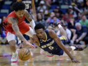 New Orleans Pelicans forward Herbert Jones (5) steals the ball from Portland Trail Blazers guard Anfernee Simons (1) in the first half of an NBA basketball game in New Orleans, Sunday, March 12, 2023.