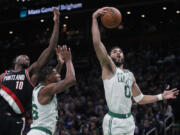 Boston Celtics forward Jayson Tatum (0) grabs a rebound against Portland Trail Blazers forward Nassir Little (10) during the second half of an NBA basketball game, Wednesday, March 8, 2023, in Boston.