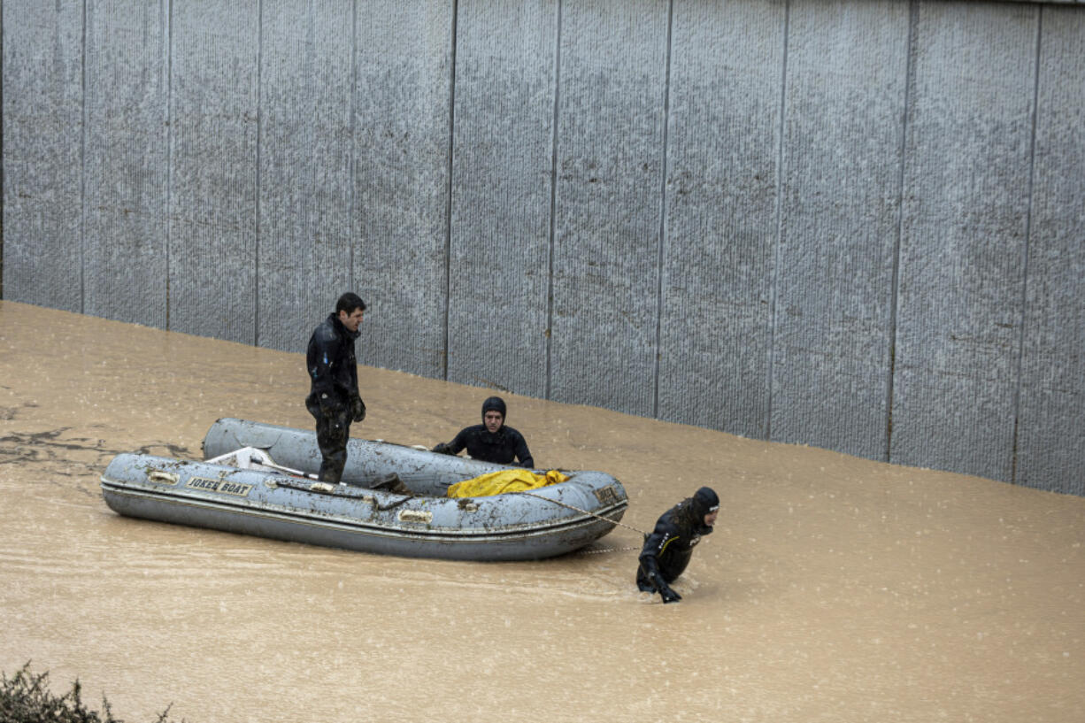 Rescue team members carry the body of a person in a rubber boat during floods after heavy rains in Sanliurfa, Turkey, Wednesday, March 15, 2023. Floods caused by torrential rains hit two provinces that were devastated by last month's earthquake, killing at least 10 people and increasing the misery for thousands who were left homeless, officials and media reports said Wednesday. At least five other people were reported missing.