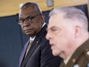 Chairman of the Joint Chiefs, Gen. Mark Milley, right, accompanied by Secretary of Defense Lloyd Austin, speaks during a briefing at the Pentagon in Washington, Wednesday, March 15, 2023.