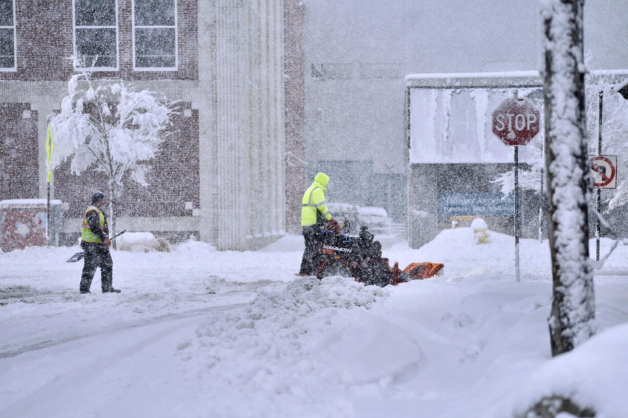 A worker plows snow on a street, Tuesday, March 14, 2023, in Pittsfield, Mass. The New England states and parts of New York are bracing for a winter storm due to last into Wednesday.