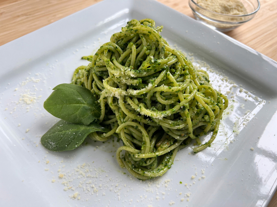 Green spaghetti is dressed in a lemony spinach pesto.
