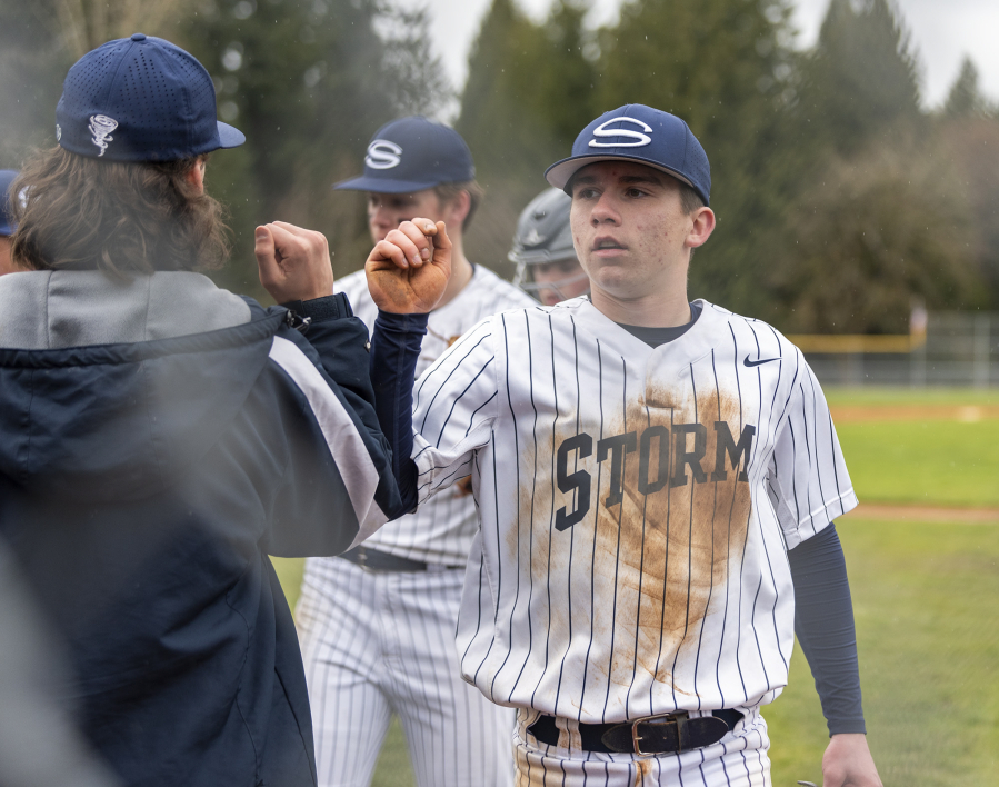 Skyview sophomore Emmett Stein, right, and others fist bump between innings Wednesday, April 5, 2023, during the Storm's 6-2 win against Prairie at Skyview High School. It was Skyview's first game at its home field in 7 years.