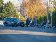 Vancouver police Officer Tyler Chavers, a member of the city's Homeless Assistance and Resources Team, photographs an illegal encampment in downtown Vancouver in December after asking the inhabitants to move to sanctioned locations.