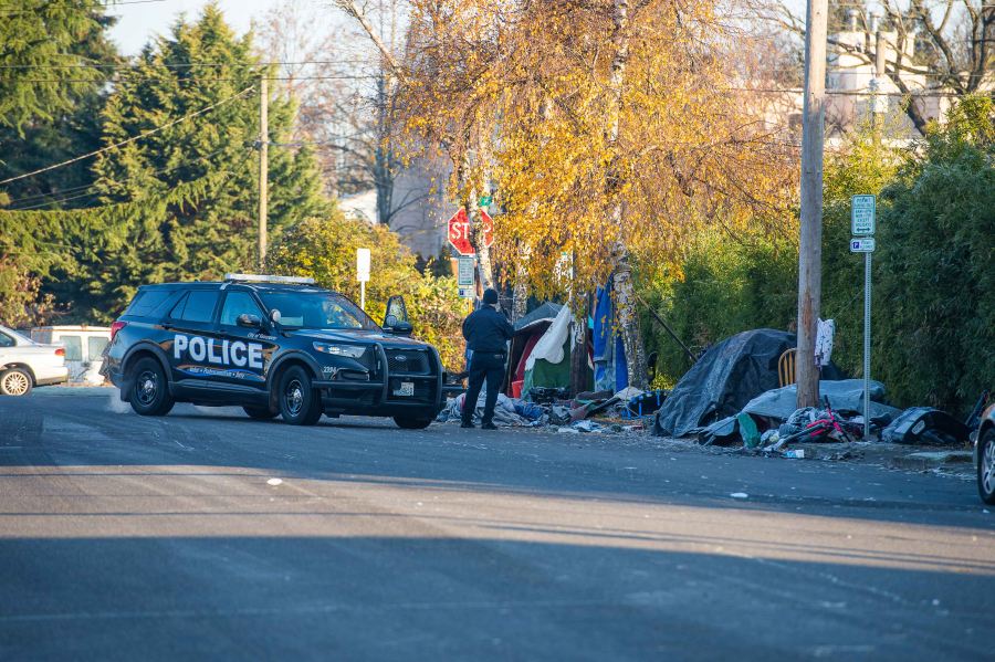 Vancouver police Officer Tyler Chavers, a member of the city's Homeless Assistance and Resources Team, photographs an illegal encampment in downtown Vancouver in December after asking the inhabitants to move to sanctioned locations.