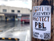 A sign asking the community to "Fight for Discovery" hangs April 7 in downtown Camas.