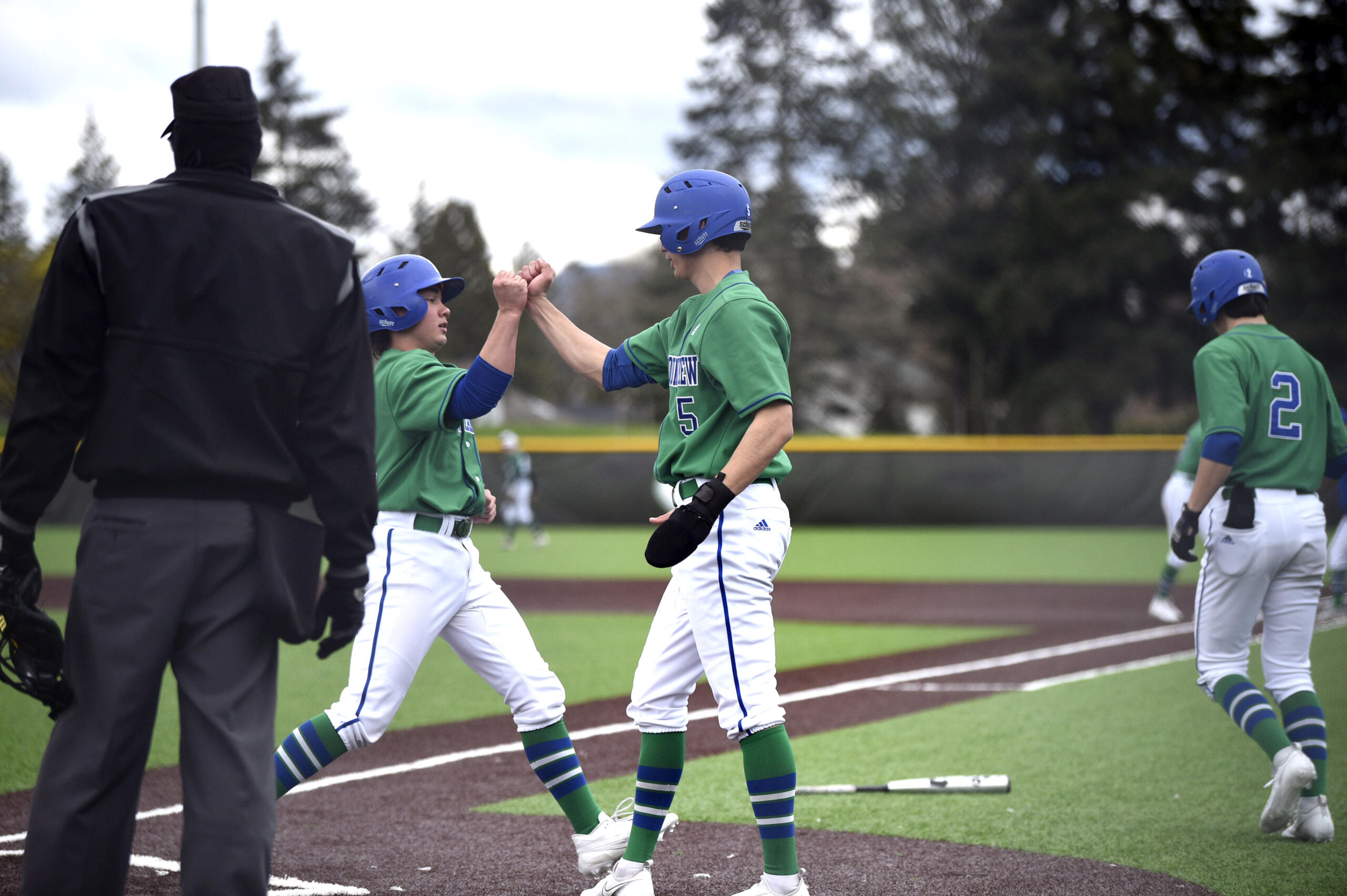 Mountain View’s Jett Hamilton and Jacob Martin embrace at home plate after each scored runs in the first inning of a 3A Greater St. Helens League baseball game against Evergreen on Tuesday, April 18, 2023, at Evergreen High School.