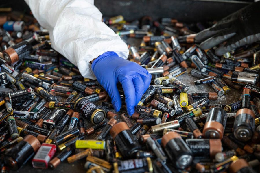 Environmental field site specialist Diana Doyle looks for lithium-ion batteries from a pile of alkaline batteries that were dropped off at the North Seattle Hazardous Waste site on Monday, Sept. 19, 2022.