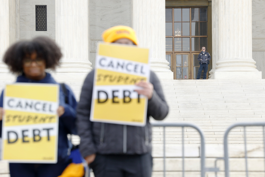 A police officer watches as student loan borrowers and advocates gather for the People's Rally to Cancel Student Debt during Supreme Court hearings on student debt relief, on Feb. 28, 2023, in Washington, D.C. Student loan relief scams are as prevalent as ever due to the ever-evolving status of loans at the federal level.