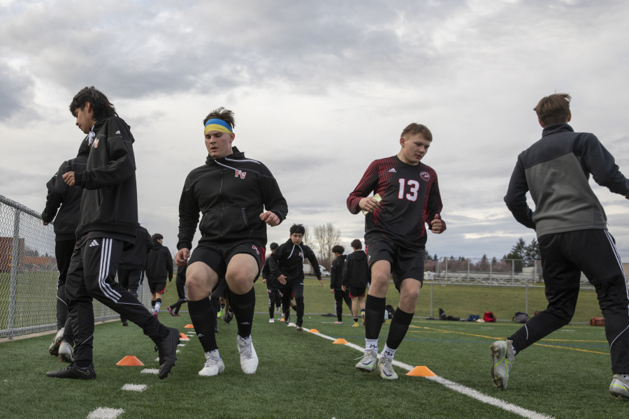 First generation Ukrainian American Denis Zayets, second from left, and Illia Strynada (13), a refugee from Ukraine, warm up with the soccer team before a match against Washougal at Fort Vancouver High School on Thursday, April 13, 2023.
