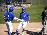 La Center’s Caden Taylor (12) greets Alex Mora (10) after scoring a run in the first inning of a Trico League baseball game on Friday, April 28, 2023, at La Center High School.