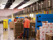 Amazon employees work inside Amazon's Kent fulfillment center in Kent, Washington, Friday, July 22, 2022.