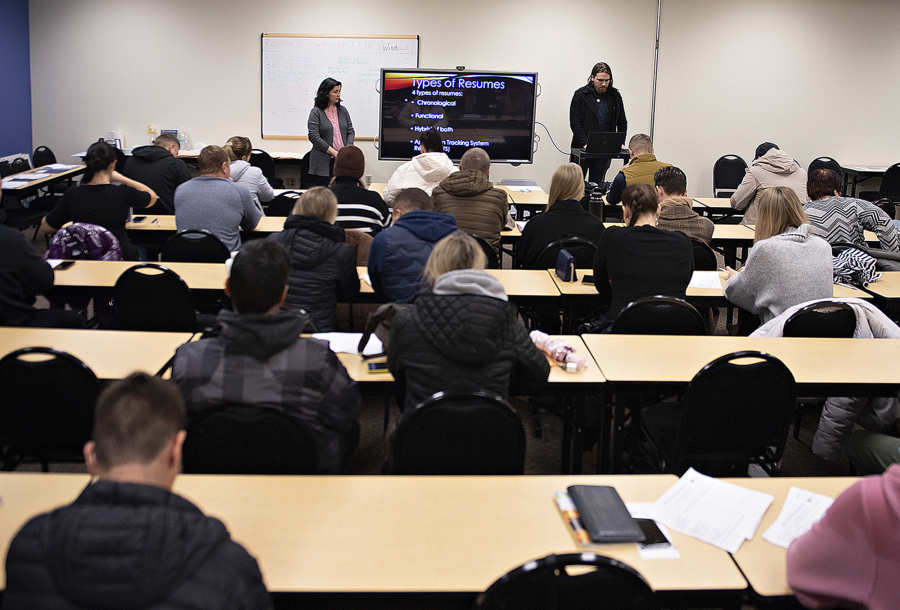 Ukrainian refugees take in a job-hunt orientation session at Partners in Careers in Vancouver. Recent Ukrainian refugee and PIC employment specialist Sasha Cheban, left, translates into Ukrainian while employment specialist Kegan Gibson, right, gives a talk in English about resumes and cover letters.