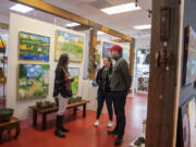 Maria Gonser of Attic Gallery, left, chats with Camas residents Robin and Kit Blair who were checking out artworks on a recent Friday morning.