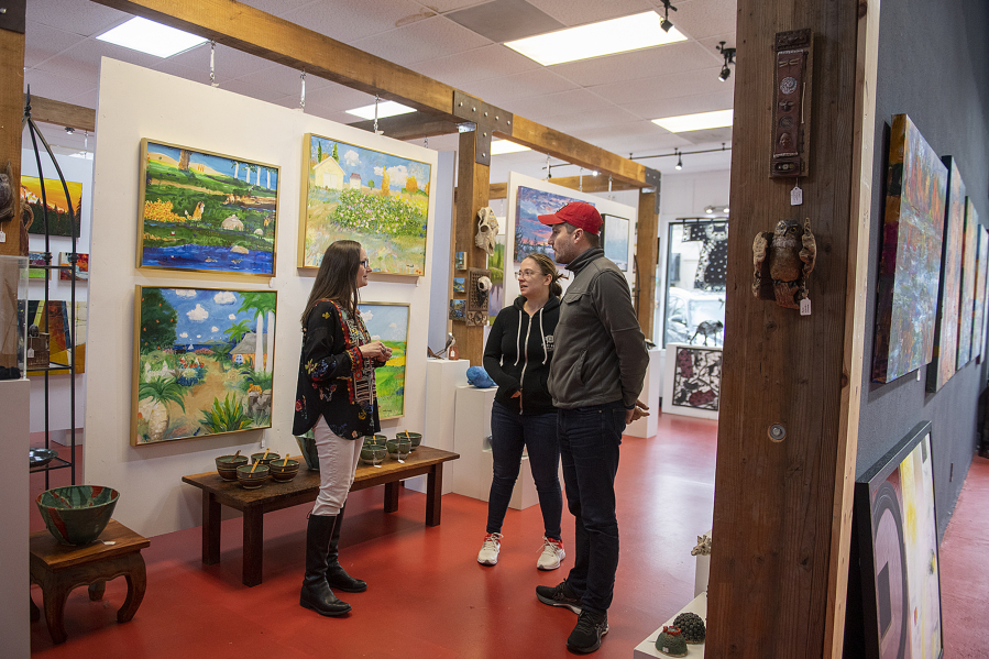 Maria Gonser of Attic Gallery, left, chats with Camas residents Robin and Kit Blair who were checking out artworks on a recent Friday morning.