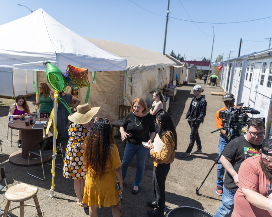 People enjoy the sunshine Friday, April 28, 2023, during a celebration of the 1-year anniversary of the Hope Village Safe Stay community on Fourth Plain Boulevard.