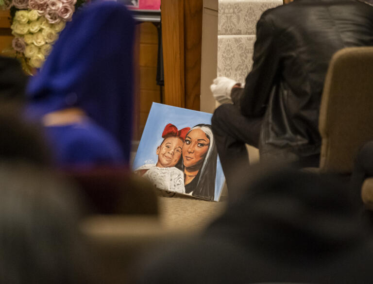 A painting of Meshay Melendez, right, and her daughter Layla Stewart, sits on the ground at the front of the room Wednesday, April 19, 2023, during the funeral for Meshay Melendez and Layla Stewart at Evergreen Memorial Gardens.