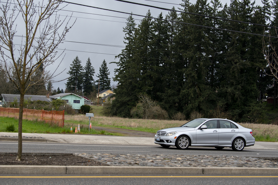 A motorist drives past the site of a possible 57-lot planned development near 12301 N.E. 18th St. The Ginn Group, which has proposed the project, is proposing a zoning change to allow for the smaller lots and smaller homes it has planned.