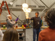 Bonneville Power Administration electrician foreman Steve Hood holds a flaming pillar of methane gas in his hand as part of a demonstration about chemical mixtures Thursday during Take Your Child To Work Day at Bonneville Power Administration's Ross Complex in Vancouver.